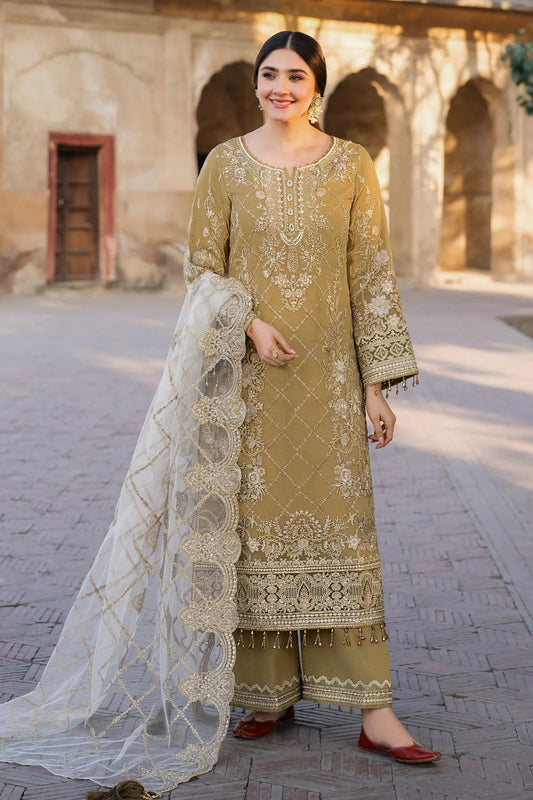 A woman wearing a traditional three-piece embroidered ensemble with a scalloped lace hem, mustard raw silk trousers, and an embroidered net dupatta with lace detailing.
