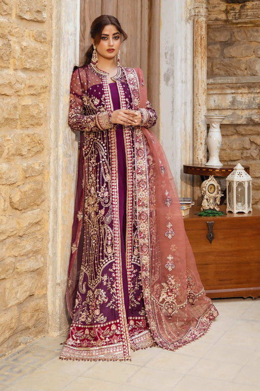 A woman wearing an embroidered purple and pink organza dress with raw silk borders and panels, along with a dupatta.