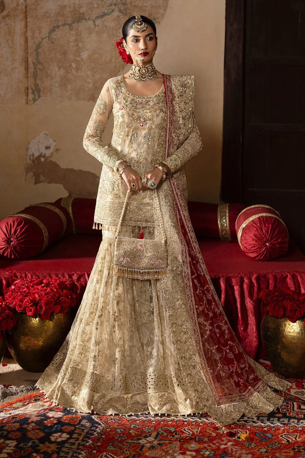 A traditional bridal outfit featuring a net dupatta, gharara, and embroidered net front and back with shimmer chiffon lining.